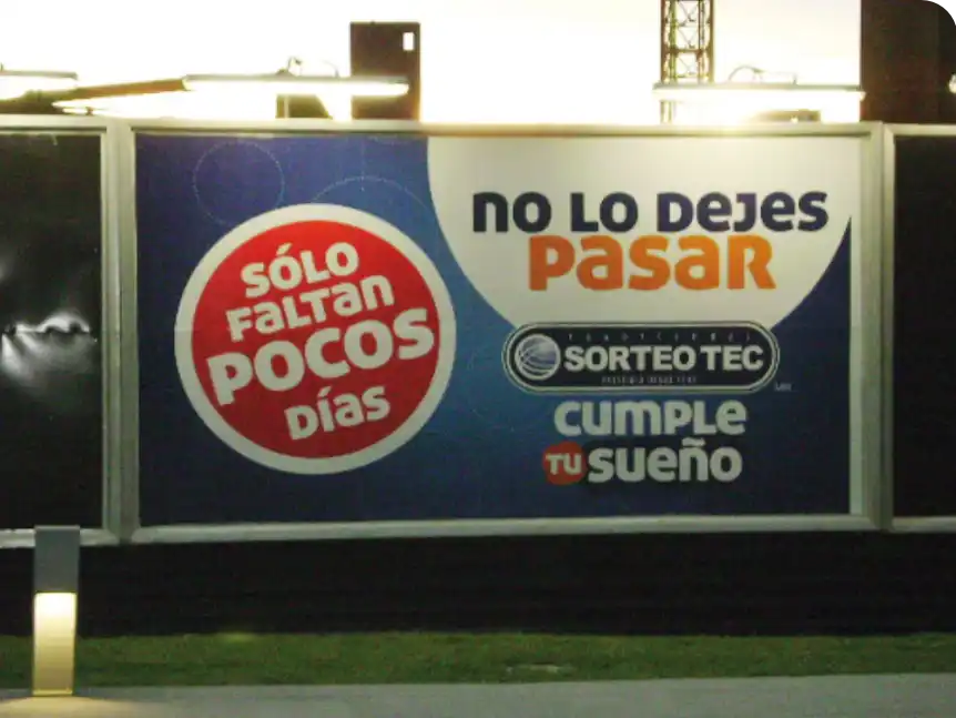 Técnico aplicando vinil publicitario sobre superficie de anuncio